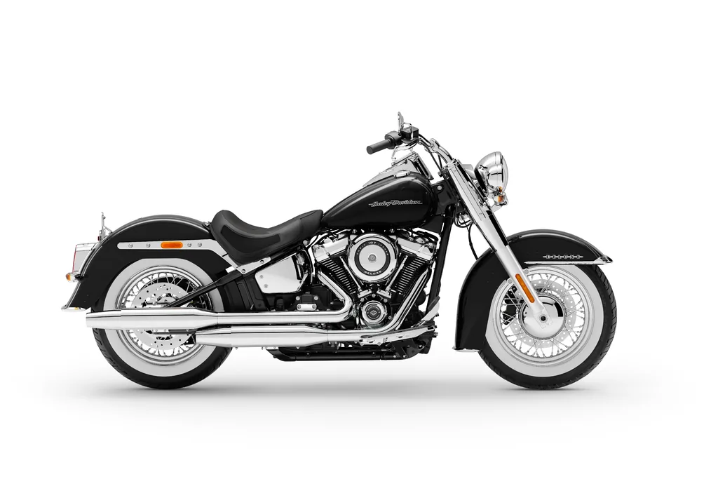 Vue studio côté droit d’une Harley-Davidson Softail Deluxe noire de 2020, avec pneus à flancs blancs, échappement chromé et marchepieds pilote.