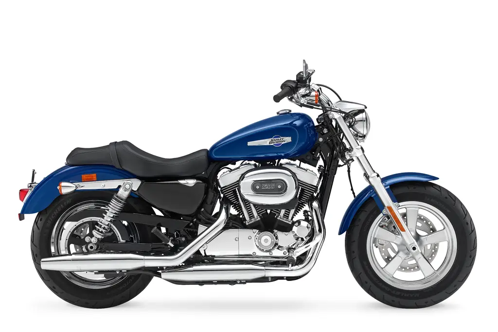 Vue côté droit d’une Harley-Davidson Sportster 1200 Custom de 2016 bleue, avec un large pneu avant.