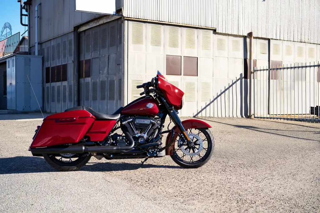 Harley-Davidson Street Glide Special 2021 rouge aux finitions noires, stationnée près d’un bâtiment industriel